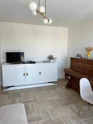 a living room with a white cabinet and a piano at Charming Flat close to beach in Cannes