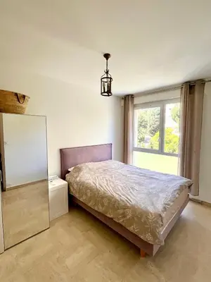 a bedroom with a bed and a mirror and a window at Charming Flat close to beach in Cannes
