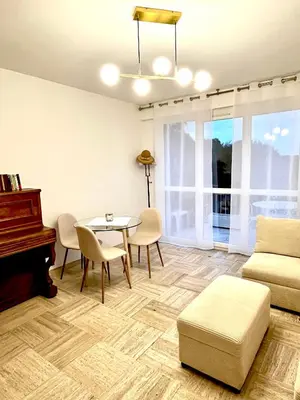 a living room with a table and a piano at Charming Flat close to beach in Cannes