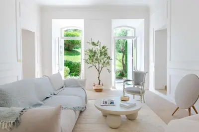 a white living room with a couch and a table at Garden-Level Apartment in Bourgeois Residence Near Croisette & Beaches in Cannes