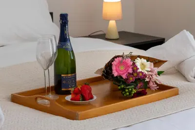a tray with a bottle of champagne and a bowl of strawberries at Garden-Level Apartment in Bourgeois Residence Near Croisette & Beaches in Cannes