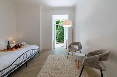 a bedroom with a bed and a table and chairs at Garden-Level Apartment in Bourgeois Residence Near Croisette & Beaches in Cannes