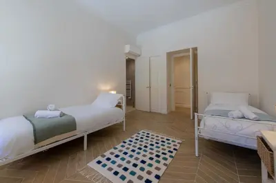 a bedroom with two beds and a rug at Garden-Level Apartment in Bourgeois Residence Near Croisette & Beaches in Cannes