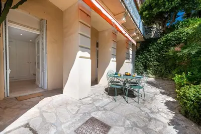 a patio with a table and chairs in front of a building at Garden-Level Apartment in Bourgeois Residence Near Croisette & Beaches in Cannes