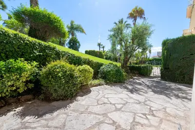 a garden with bushes and a walkway at Garden-Level Apartment in Bourgeois Residence Near Croisette & Beaches in Cannes