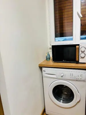 a kitchen with a washing machine and a microwave at CANNES Inn Appartement in Le Cannet