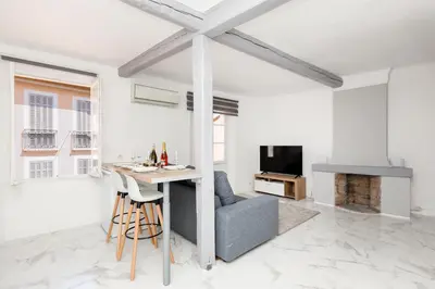 a white living room with a table and a couch at Renoveted studio - Central - AC in Cannes