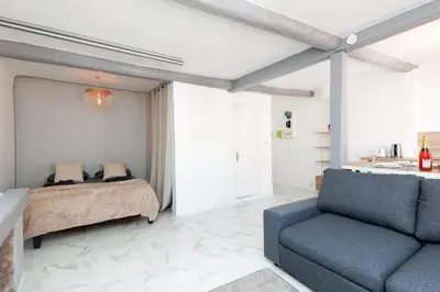 a bedroom with a bed and a blue couch at Renoveted studio - Central - AC in Cannes
