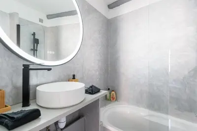 a bathroom with a white sink and a mirror at Renoveted studio - Central - AC in Cannes