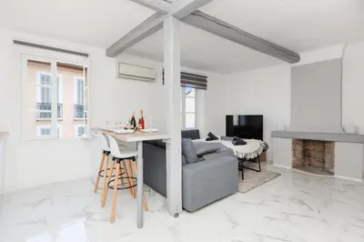 a white living room with a couch and a table at Renoveted studio - Central - AC in Cannes