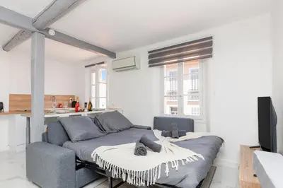a living room with a bed and a tv at Renoveted studio - Central - AC in Cannes