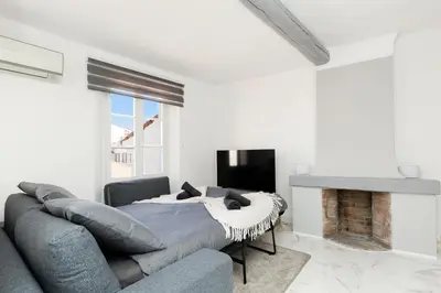 a white living room with a couch and a fireplace at Renoveted studio - Central - AC in Cannes