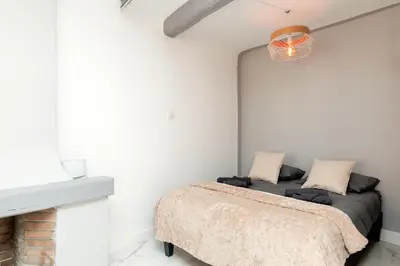 a bedroom with a bed in a white wall at Renoveted studio - Central - AC in Cannes