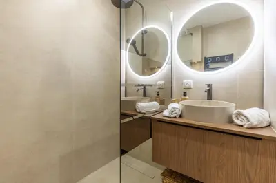 a bathroom with two sinks and a mirror at LB Vacation Rentals I Beautiful 2BR Apt, Renovated in 2025, La Croisette, Minutes from Beach and Palais in Cannes