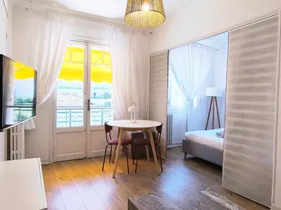 a room with a table and a bed and a window at Studio au calme 100 mètres de la croisette in Cannes