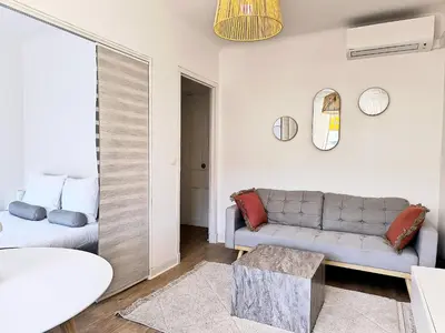 a living room with a couch and a table at Studio au calme 100 mètres de la croisette in Cannes