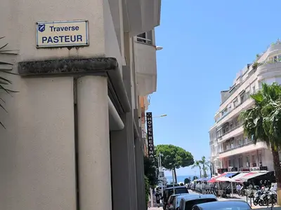 a sign on the side of a building with cars parked at Studio au calme 100 mètres de la croisette in Cannes
