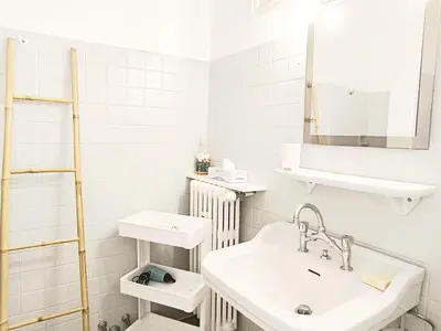 a white bathroom with a sink and a mirror at Studio au calme 100 mètres de la croisette in Cannes