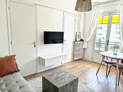 a living room with a couch and a tv on a wall at Studio au calme 100 mètres de la croisette in Cannes