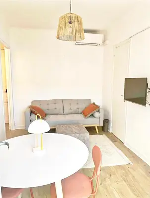 a living room with a white table and a couch at Studio au calme 100 mètres de la croisette in Cannes