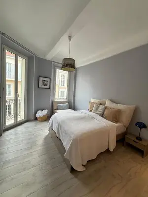 a bedroom with a large bed and a large window at Foch 1 - Luminous apartment in city center w balcony in Cannes