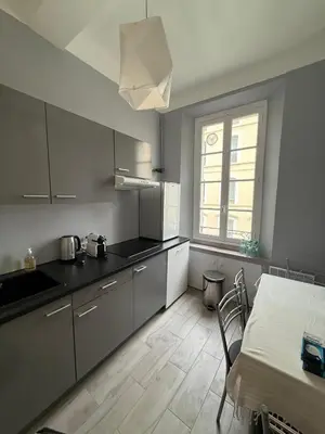 a kitchen with a table and a window and a table and chairs at Foch 1 - Luminous apartment in city center w balcony in Cannes