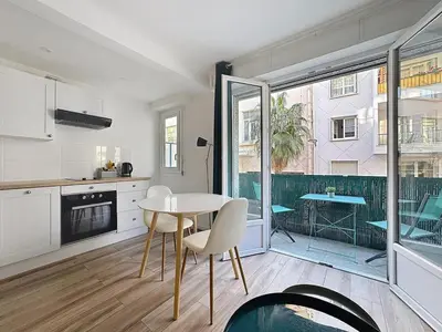 a kitchen and dining room with a table and chairs at Studio proche gare, balcon in Cannes