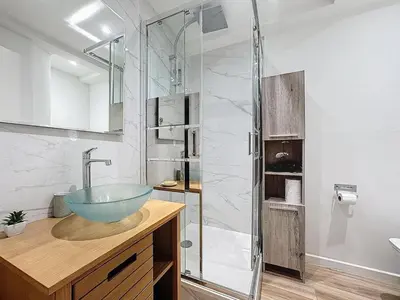 a bathroom with a sink and a glass shower at Studio proche gare, balcon in Cannes