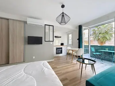 a living room with a couch and a table at Studio proche gare, balcon in Cannes