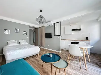 a bedroom with a bed and a table and chairs at Studio proche gare, balcon in Cannes