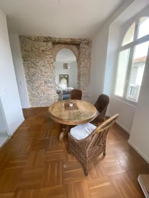 a dining room with a wooden table and chairs at Lisa Appartement de charme in Cannes