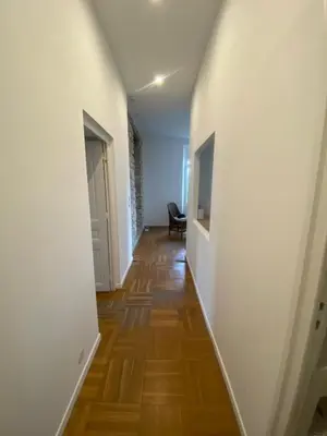 a hallway with white walls and a wooden floor at Lisa Appartement de charme in Cannes