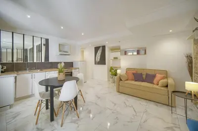 a kitchen and living room with a couch and a table at Le Jo - Centre - Terrasse - Verrière Côte d'Azur in Cannes