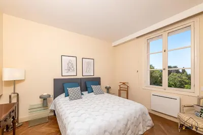 a bedroom with a bed and a desk and a window at La Gloriette Azur piscine sauna vue mer in Cannes