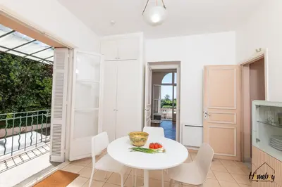 a kitchen and dining room with a white table and chairs at La Gloriette Azur piscine sauna vue mer in Cannes