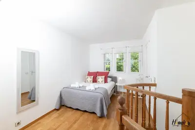 a white bedroom with a bed and a mirror at La Gloriette Azur piscine sauna vue mer in Cannes
