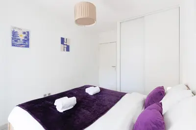 a white bedroom with two towels on a bed at Cannes Maria YourHostHelper in Cannes