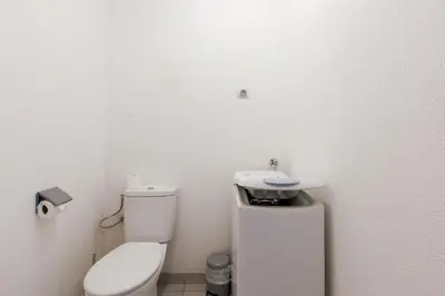 a white bathroom with a toilet and a sink at Cannes Maria YourHostHelper in Cannes