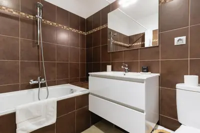 a bathroom with a tub and a sink and a toilet at Cannes Maria YourHostHelper in Cannes
