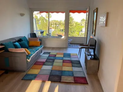a living room with a couch and a colorful rug at Appartement moderne avec vue mer à Cannes in Cannes