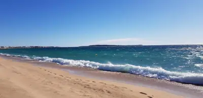a beach with a wave in the ocean at Appartement moderne avec vue mer à Cannes in Cannes