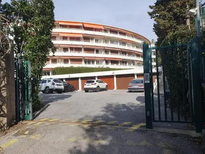 a parking lot with cars parked in front of a building at Appartement moderne avec vue mer à Cannes in Cannes