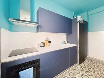 a kitchen with blue and white cabinets and a sink at Vega in Cannes