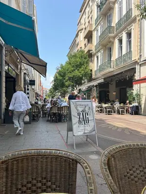 a sign on a street with people sitting at tables at Entire studio Cannes Raphael in Cannes