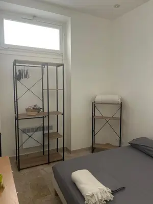 a bedroom with a bed and a window and shelves at Entire studio Cannes Raphael in Cannes