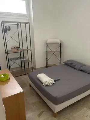 a bedroom with a bed and a window and shelves at Entire studio Cannes Raphael in Cannes