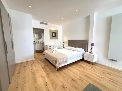 a bedroom with a white bed and a wooden floor at Palais Miramar Croisette 2 BRD Gold Suite in Cannes