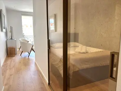 a bedroom with a bed and a sliding glass door at Palais Miramar Croisette 2 BRD Gold Suite in Cannes