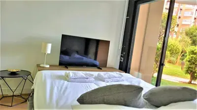 a bedroom with a bed with a tv on the wall at Beachfront 4 people 2 swimming pool in Cannes