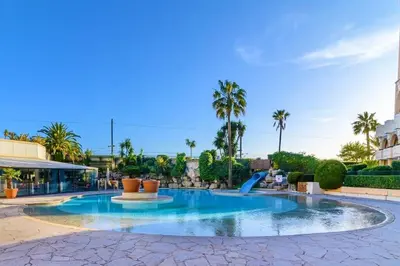 a swimming pool in a resort with palm trees at Beachfront 4 people 2 swimming pool in Cannes